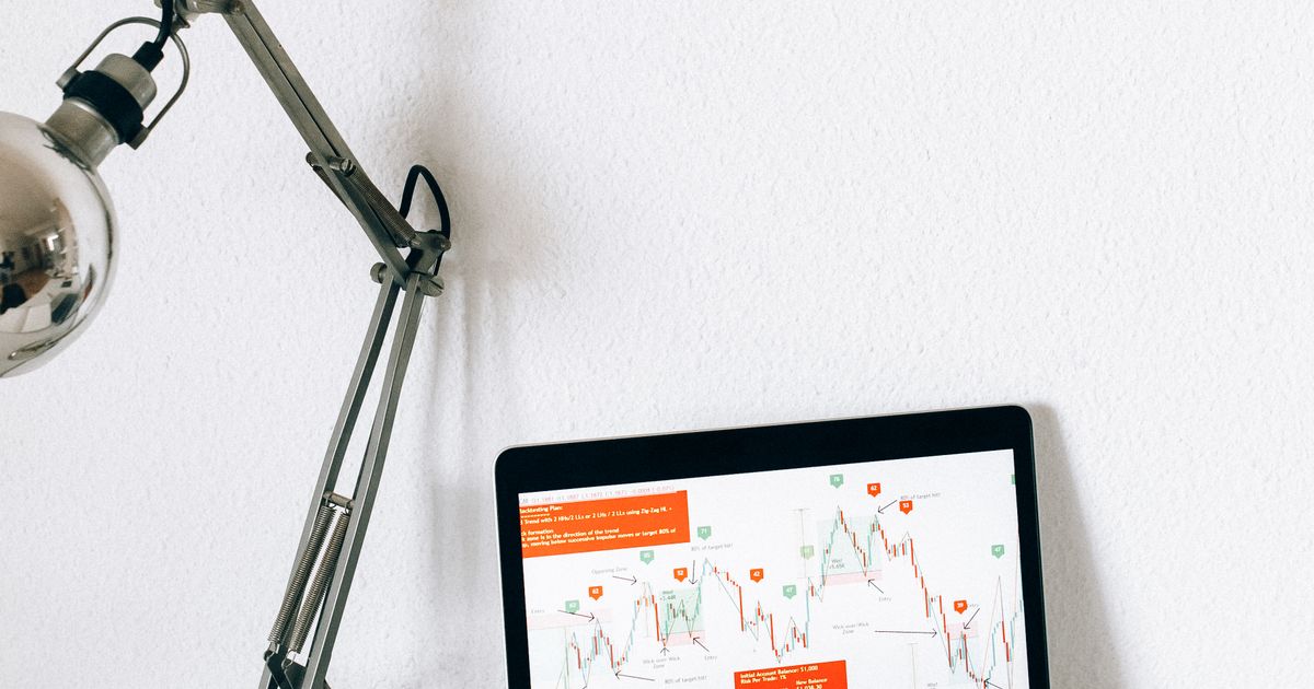 Laptop showing multiple data charts beside a research notebook.