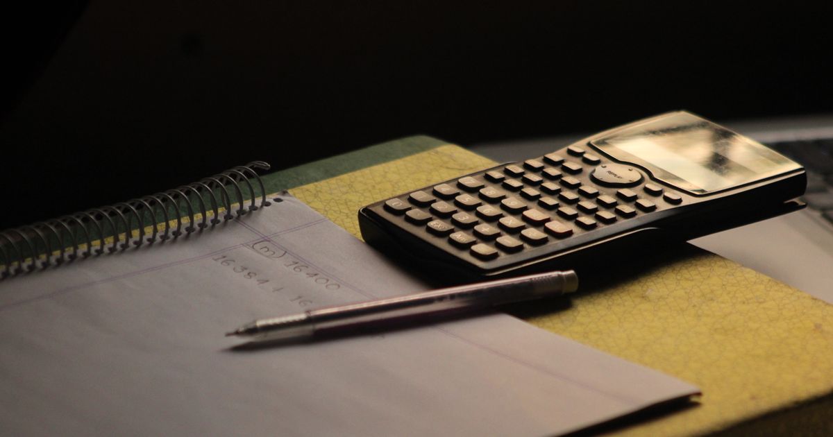 Calculator and research notebook on a study desk.